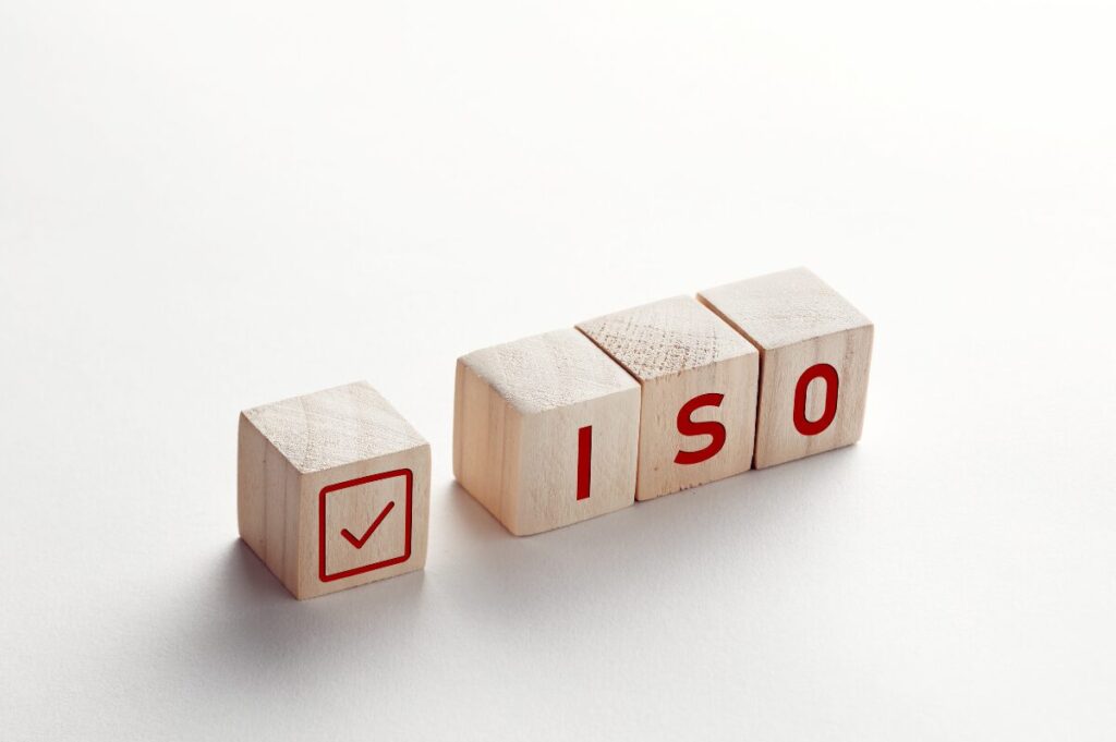 4 wooden blocks with a tick and the letters ISO on them to accompany a 4 Oaks Health & Safety news article